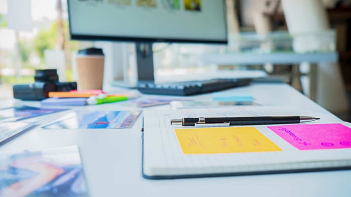 um computador e papeis na mesa sinalizando planejamentopara branded e no-branded