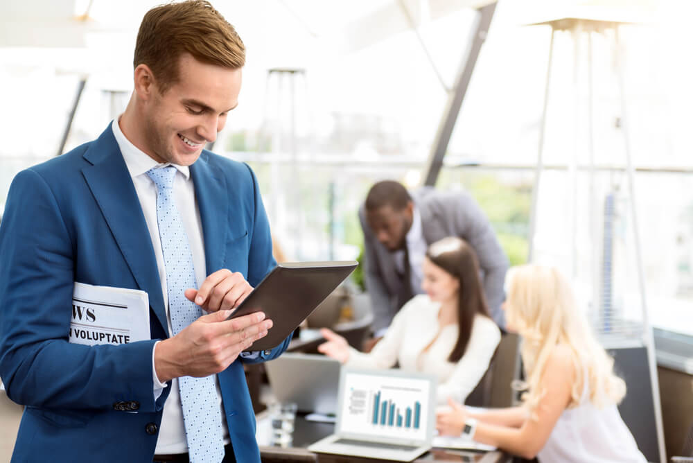equipe de trabalho e homem em destaque sorridente com jornal e tablet