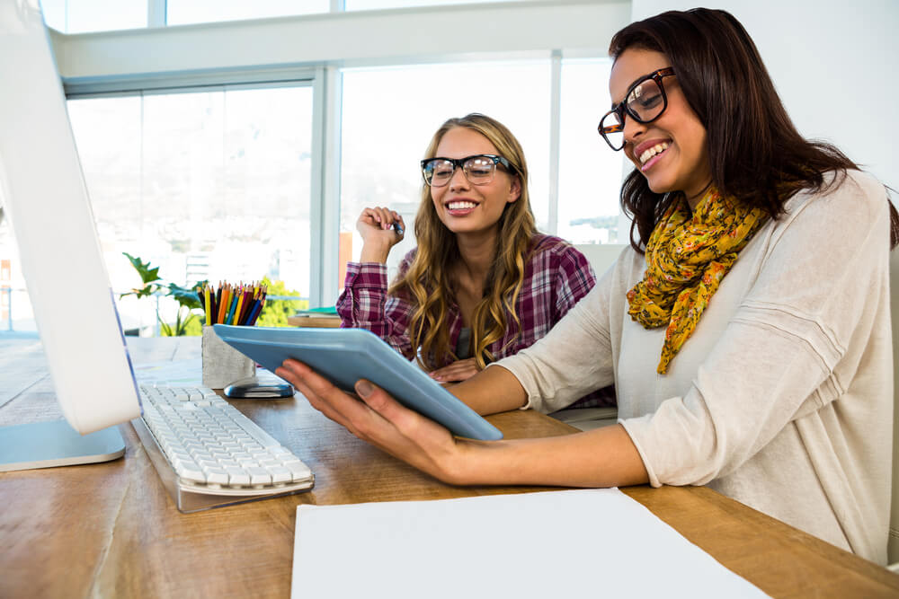 garotas jovens a frente de computador acessando tablet
