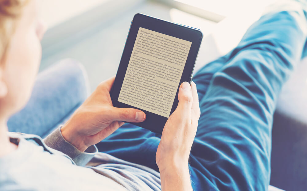 homem sentado segurando ebook