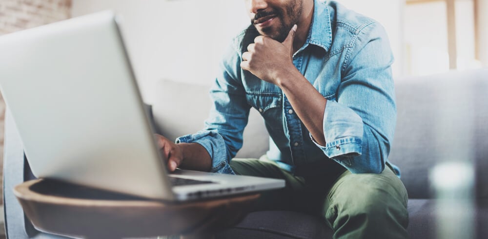 Homem sentado utilizando o notebook para criar as melhores técnicas de CRO