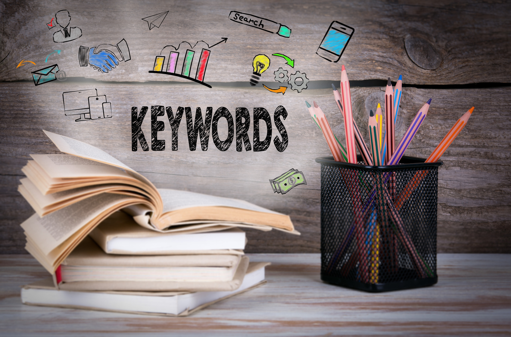 Keywords, Business Concept. Stack of books and pencils on the wooden table.