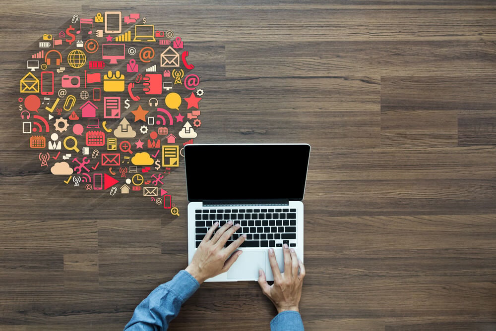 laptop com representação de balão de conversa com simbolos diversos