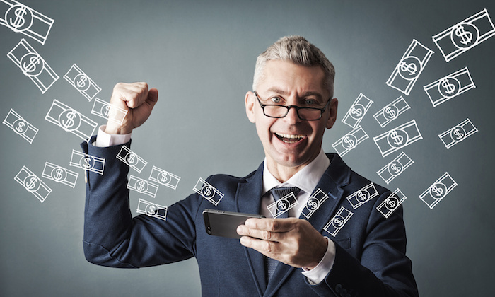 Technology, online banking, money transfer, e-commerce concept. Businessman using smartphone dollar bills flying