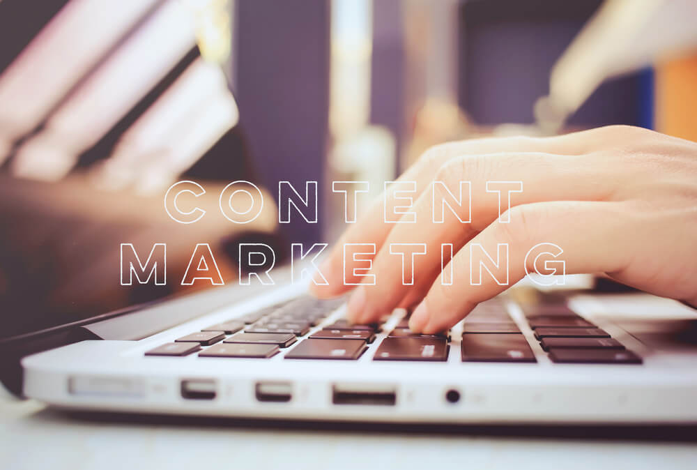 mãos acessando laptop com título conteúdo de marketing no inglês