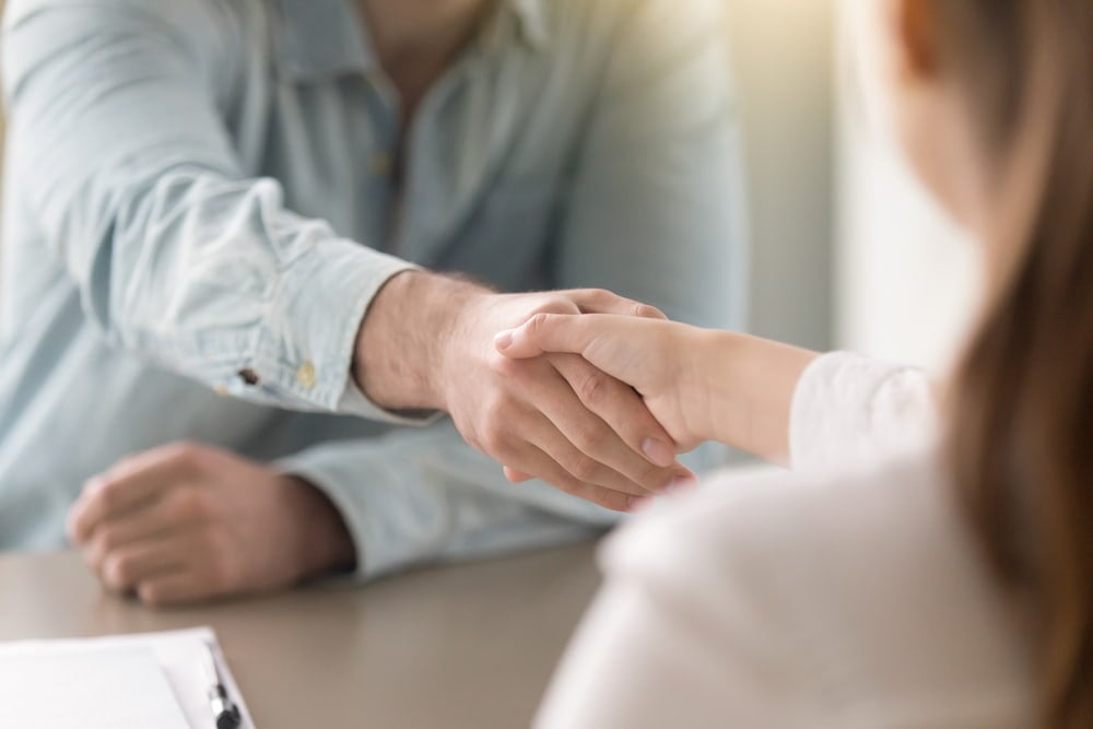 profissionais na area de marketing apertando maos simbolizando fechamento de negocios